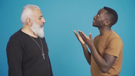 African-muslim-man-and-christian-man-inform-each-other-about-their-religion-and-friendly-smiling-at-camera.
